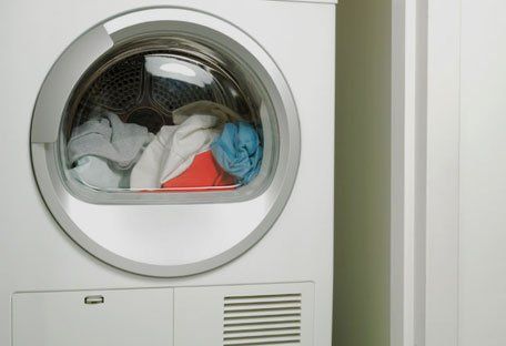 Dryer door with laundry visible inside.